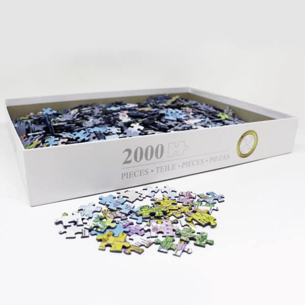 geöffneter Puzzle-Karton mit einem kleinen Haufen Puzzle-Teile